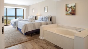 Un dormitorio con dos camas, un ventanal con vistas, una bañera y un cuadro en la pared.
