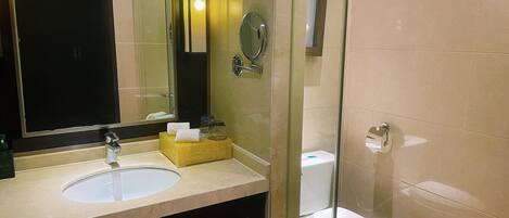 Un baño con lavamanos, espejo e inodoro.