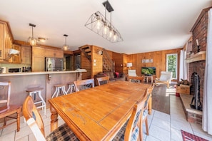 A spacious kitchen with wooden cabinets, a central island, and a dining area with a large wooden table and chairs.