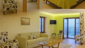 Ein Hotelzimmer mit Bett, Sessel, Sofa und Fernseher.