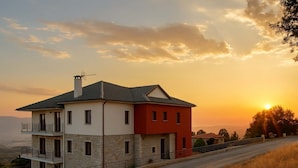 Ein zweistöckiges Haus mit Balkon, Stein-Fassade und rotem Abschnitt.