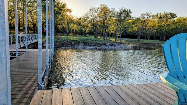 A wooden deck with a view of a river and trees.