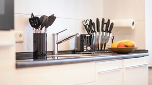 A modern kitchen with a stainless steel sink, a toaster, and a bowl of fruit on the counter. - Bright apartment in the heart of Mönchengladbach (Mönchengladbach)