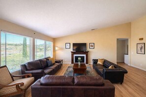 A living room with two sofas, a coffee table, a fireplace, and large windows. - Private Temecula Getaway | Walk to Wineries (Temecula)