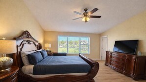 A bedroom with a large bed, a ceiling fan, a TV, and a window with a view. - Private Temecula Getaway | Walk to Wineries (Temecula)
