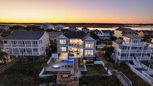 Une propriété située en bord de mer, comprenant plusieurs maisons, une piscine et un quai.