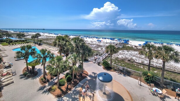 Un resort con piscina, playa y vista al océano.