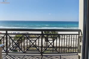 Un balcon avec vue sur la plage et l’océan.
