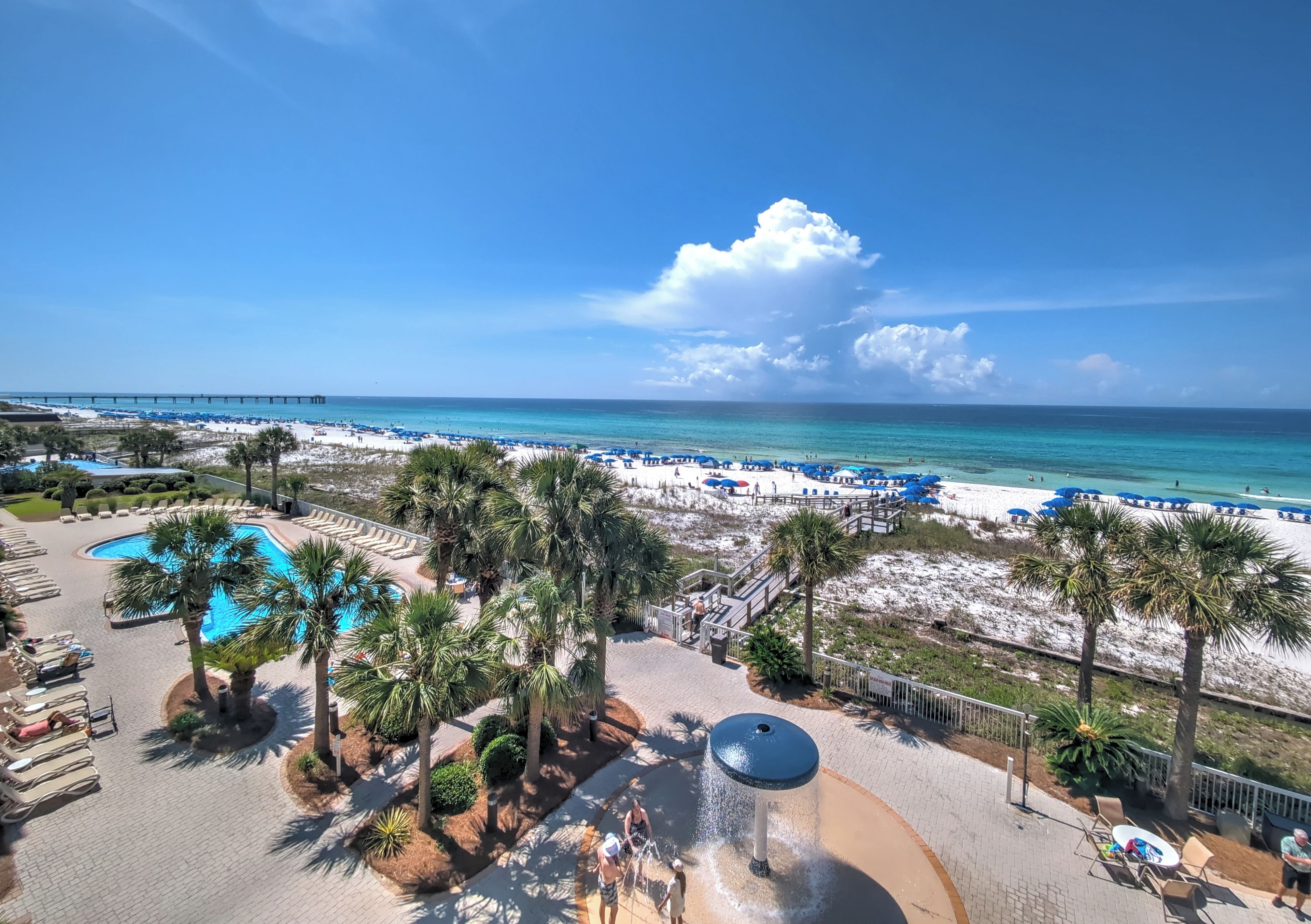 Een resort met zwembad, strand en uitzicht op de oceaan.
