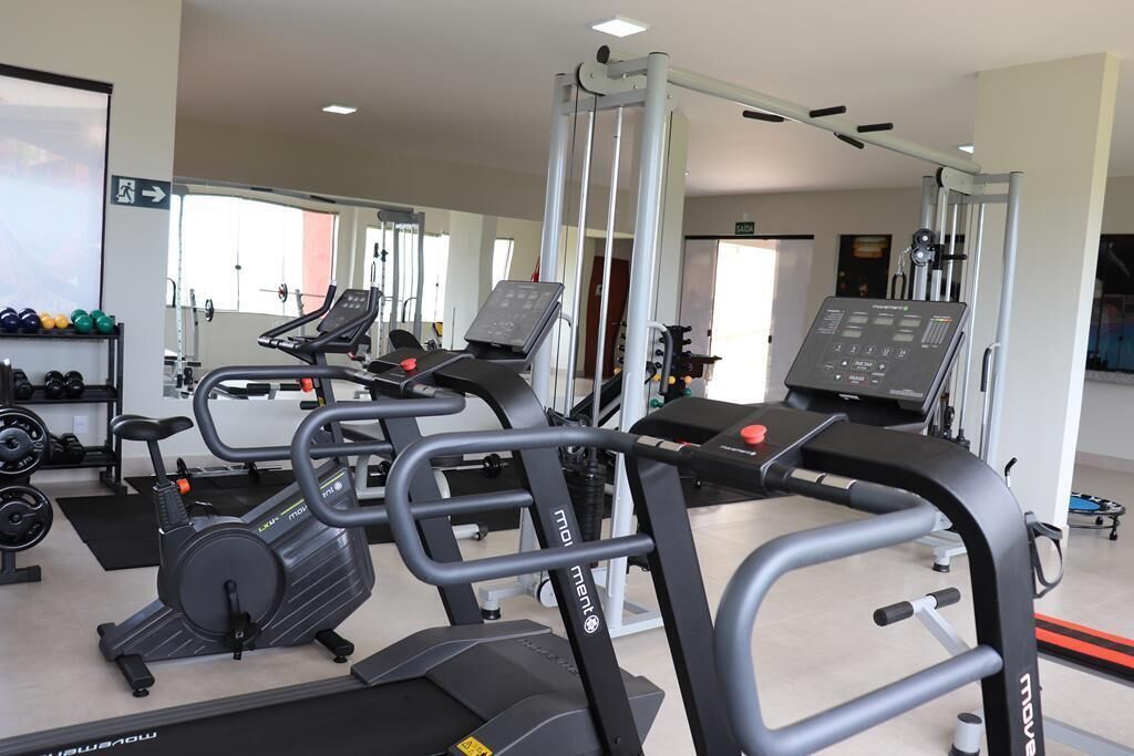 A gym with treadmills, weight machines, and a mirror.