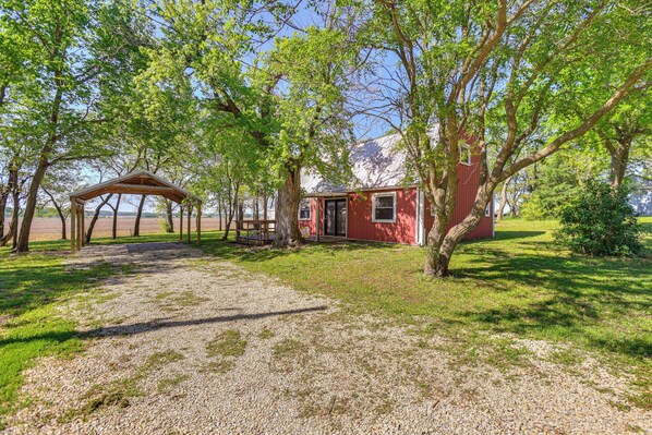 A rustic cabin with a wooden gazebo, surrounded by trees and a gravel path. - Countryside Escape 14 Mi to Milford & Geary Lakes! (Chapman)