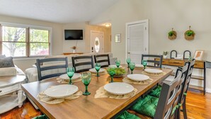 A dining area with a wooden table set for four, green glassware, and a green cushioned bench.