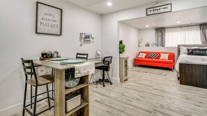 A modern living room with a dining area, a red sofa, and a bed. - Cozy Couple's Retreat in Salt Lake City Area! (Magna)