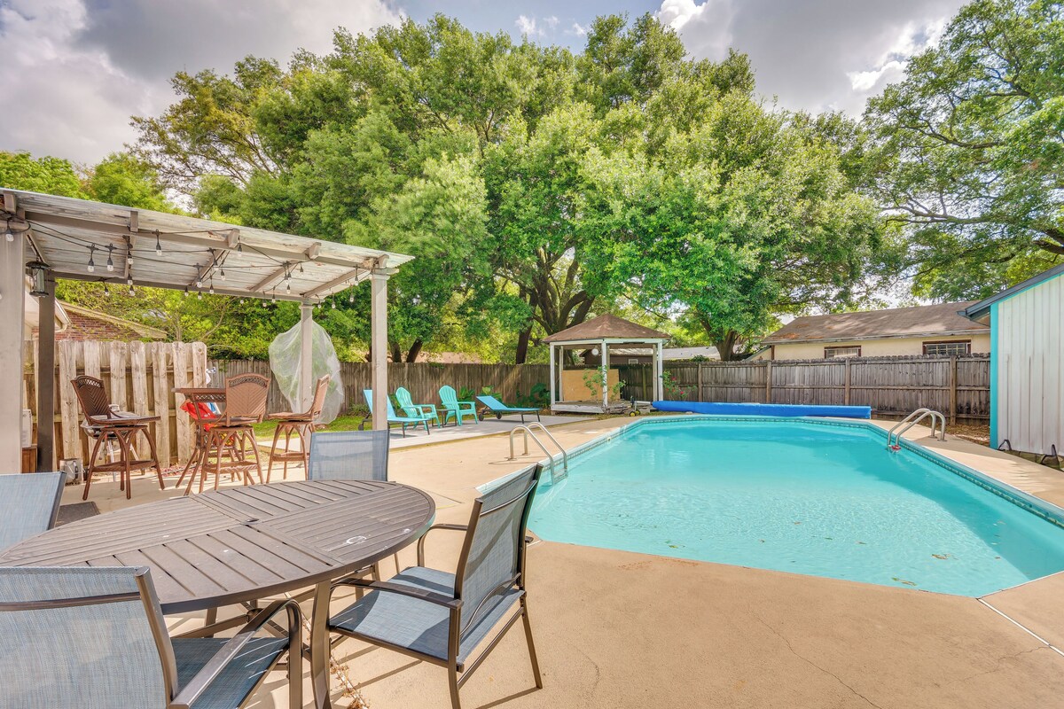 A backyard with a swimming pool, patio furniture, and a gazebo.