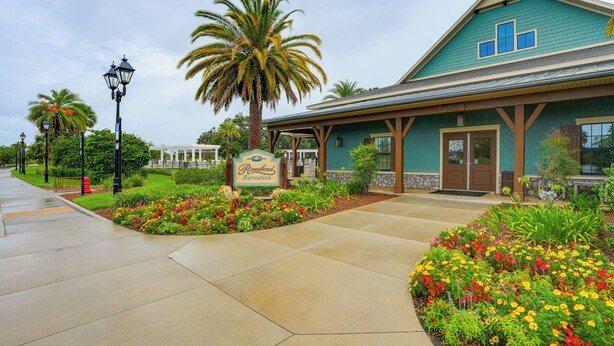 A building with a sign reading "Riversend Recreation" and a covered walkway with flower beds. - Walk to Community Perks: Home in The Villages (The Villages)