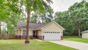 A single-story house with a garage, a front porch, and a well-maintained lawn. - Deck & Yard: Savannah Area Retreat! (Pooler)