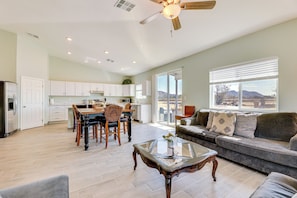 Relax in this inviting living area with a large window offering a view of the outdoors, a comfortable sofa, and a dining space.