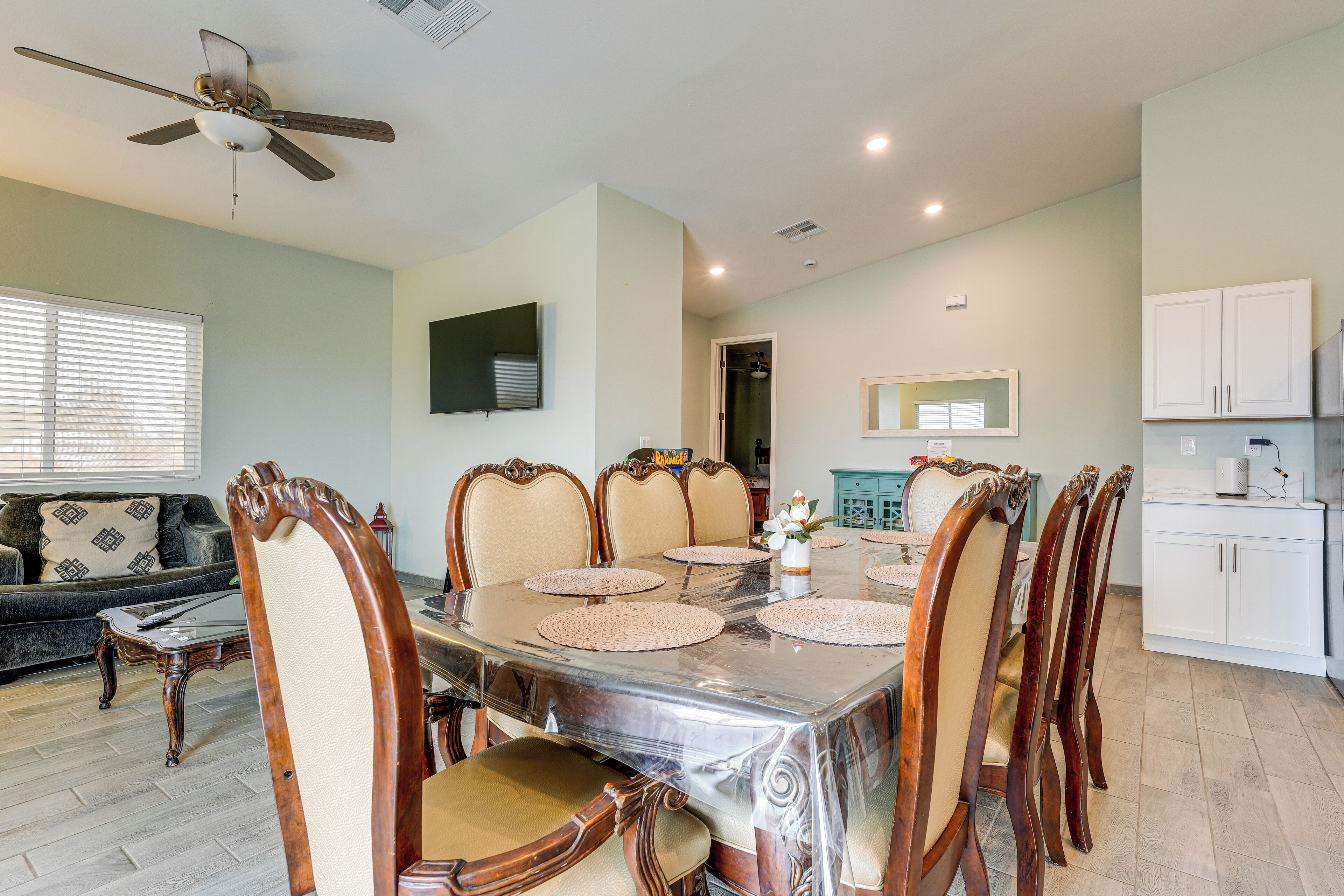 A dining area with a table, chairs, and a ceiling fan.