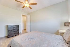Relax in comfort with a large bed, ceiling fan, and convenient bedside table.