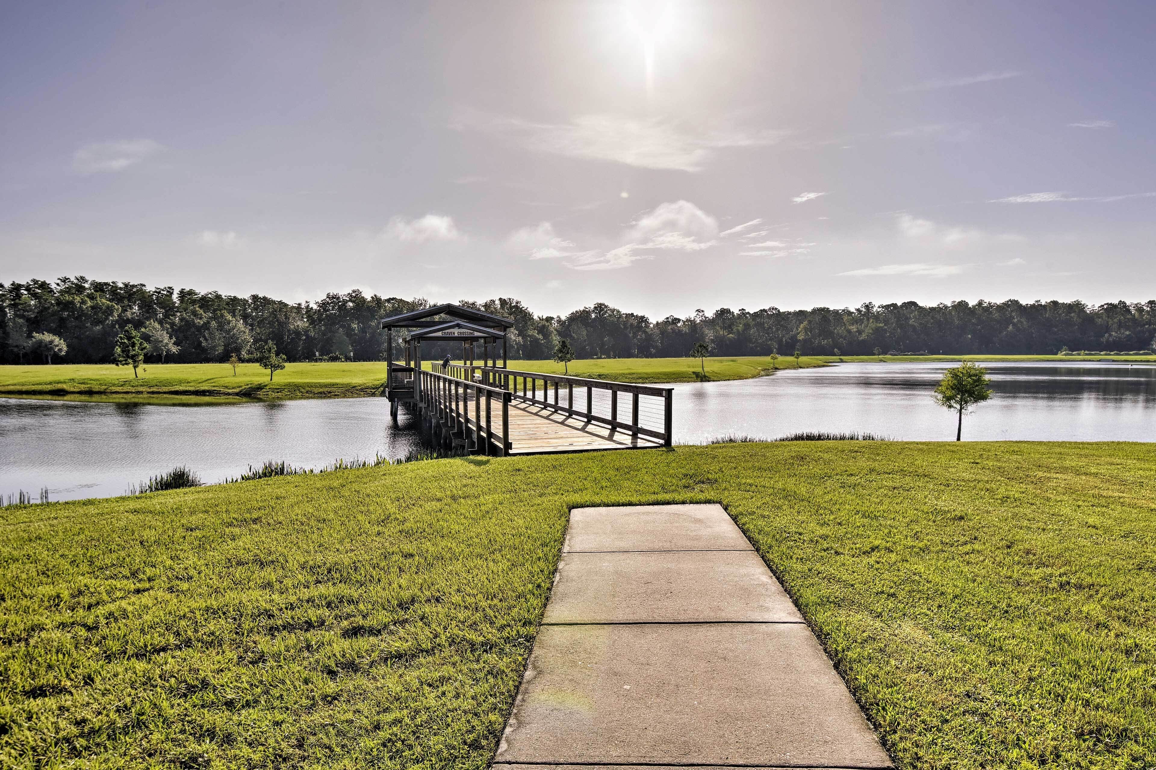A tranquil lakeside scene with a wooden dock leading to a gazebo.