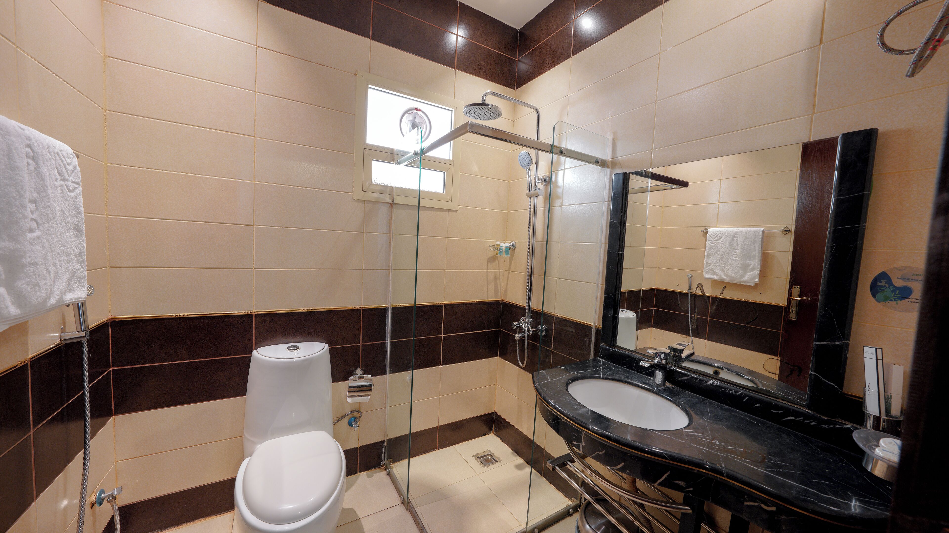 A bathroom with two sinks, a toilet, a shower, and a large mirror.