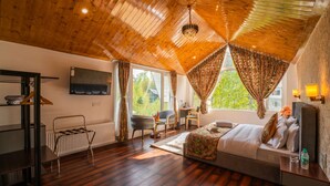 A bedroom with a wooden ceiling, a bed, a desk, and a chair. - Moustache Pahalgam (Anantnag)