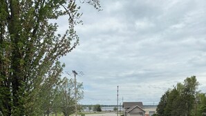 A grassy outdoor area with a fenced garden, a bench, and a view of a building in the distance. - Muskegon Lake View Loft studio/kitchenette (Muskegon)
