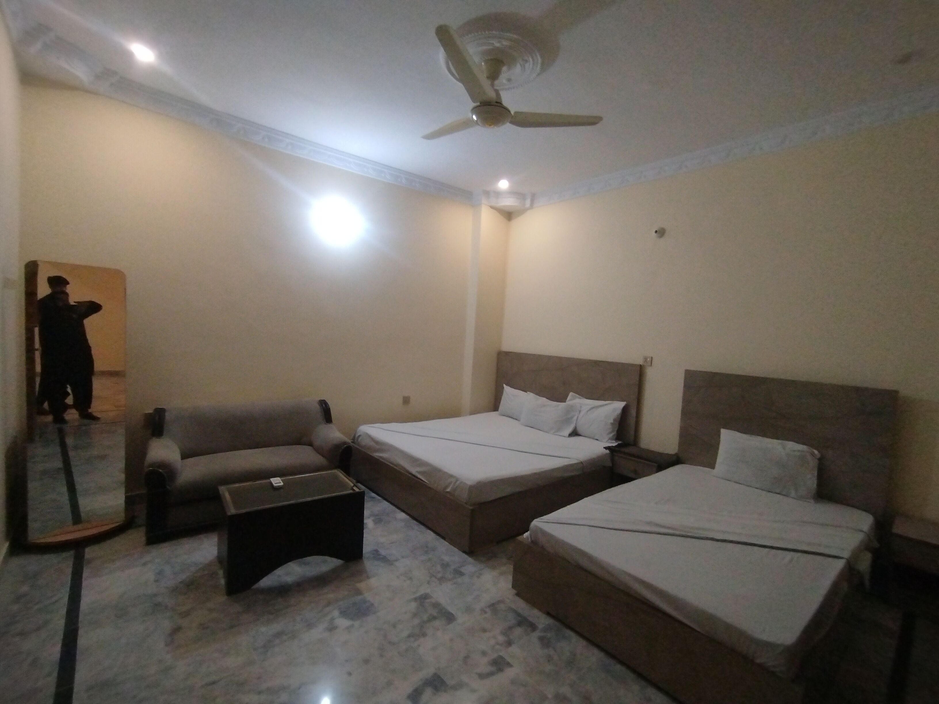 Una habitación de hotel con cama, sofá y una pequeña mesa.
