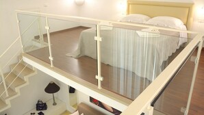 A bedroom with a bed, a glass-enclosed balcony, and a staircase. - Room-pistis Room - Santa Sofia Martano (Martano)