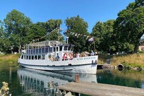 A boat named 'Kung Sverker' docked at a pier with a wooden walkway and a tunnel entrance in the background. - Charming Swedish Forest Cottage Motala (Motala)