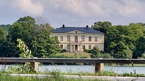 A large, two-story building with a symmetrical facade, a central entrance, and a flat roof. - Charming Swedish Forest Cottage Motala (Motala)