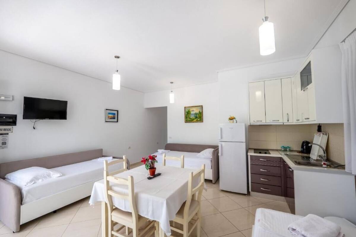 Une chambre d’hôtel compacte comprenant un coin cuisine, un espace repas et deux lits simples.