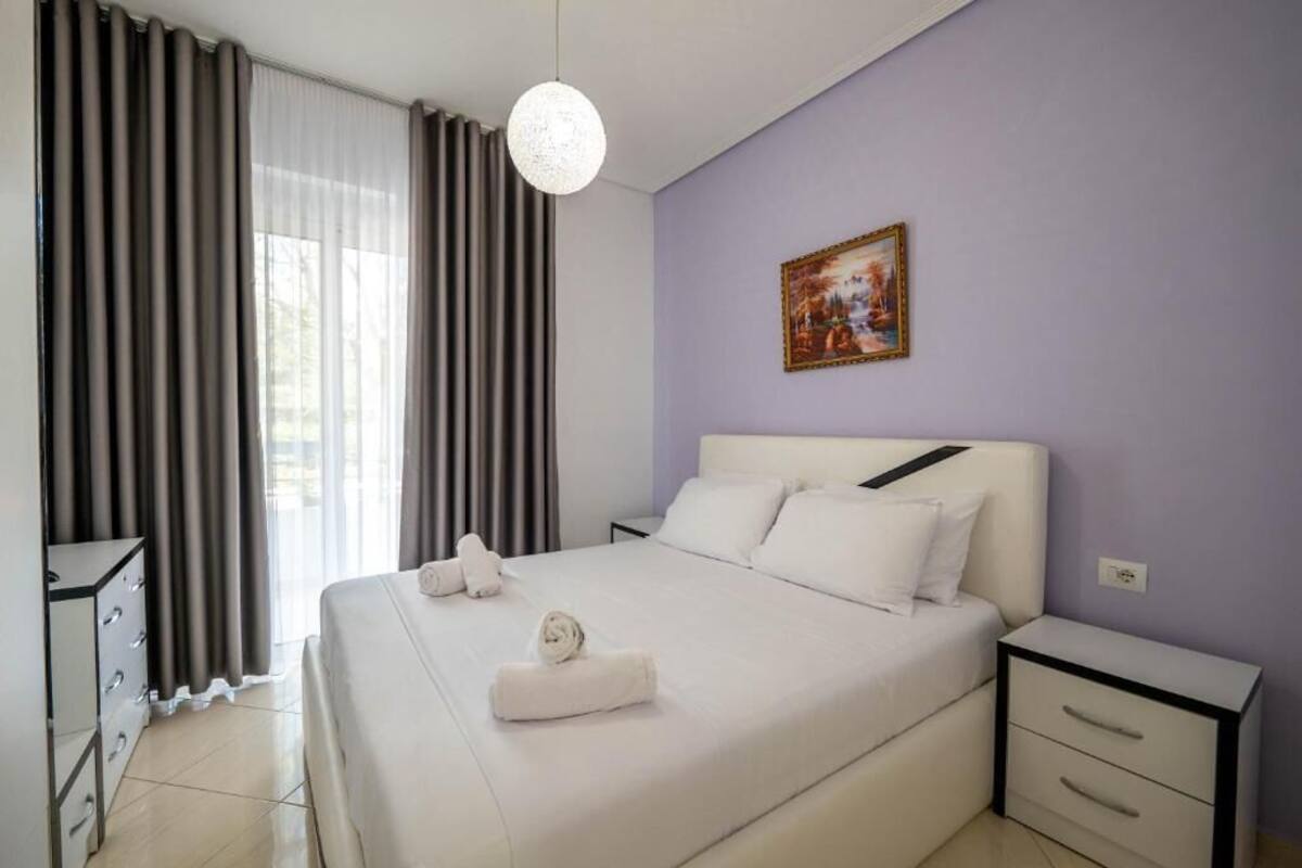 Une chambre d’hôtel avec un grand lit, une table de chevet, une armoire et un tableau au mur.