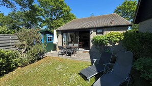A house with a patio, a dining area with chairs, and a small garden. - Pet-free vacation home on the North Sea (Ellemeet)