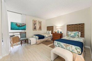 A hotel room with two beds, a desk, a chair, and a television. - Beachfront Bliss at Kona By The Sea #312 - Saltwater Pool & Central AC (Kailua-Kona)
