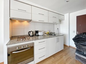 Enjoy cooking in this well-equipped kitchen with an oven, stainless steel range hood, and modern sink.