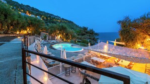 A pool area with lounge chairs and umbrellas, surrounded by a deck with a railing. - Holiday Resort Balzi Rossi (Ventimiglia)