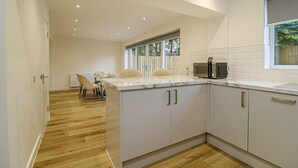 A modern kitchen with white cabinets, a marble countertop, and a built-in microwave. - Beautiful 3 Bed Luxury House in Glasgow West End (Glasgow City)