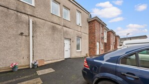 A residential building with a flat facade, a door marked '51A', and a parked car.