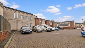 A parking area with several cars and a white van.