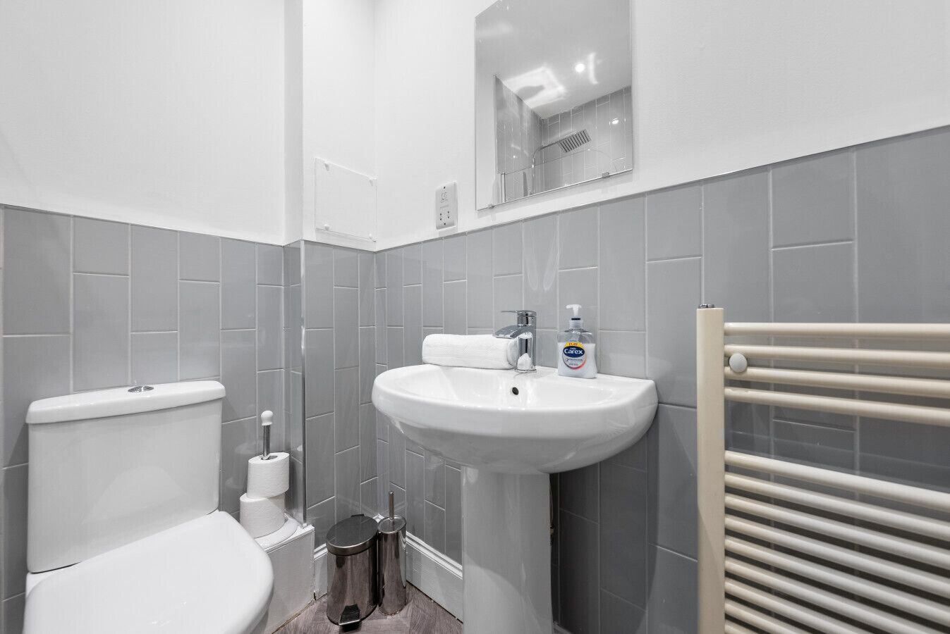 Une salle de bain moderne avec des toilettes, un lavabo et un miroir.