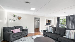 A modern living room with two grey sofas, a round coffee table, and a white rug.