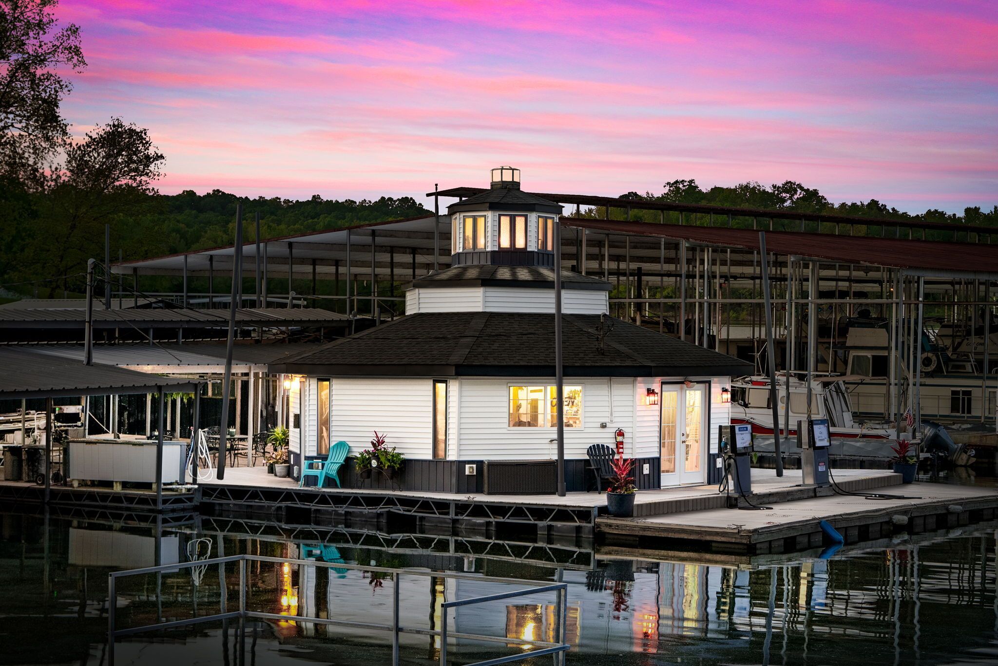 Un bâtiment situé au bord du quai, doté d’une terrasse couverte et d’un petit abri pour bateaux.