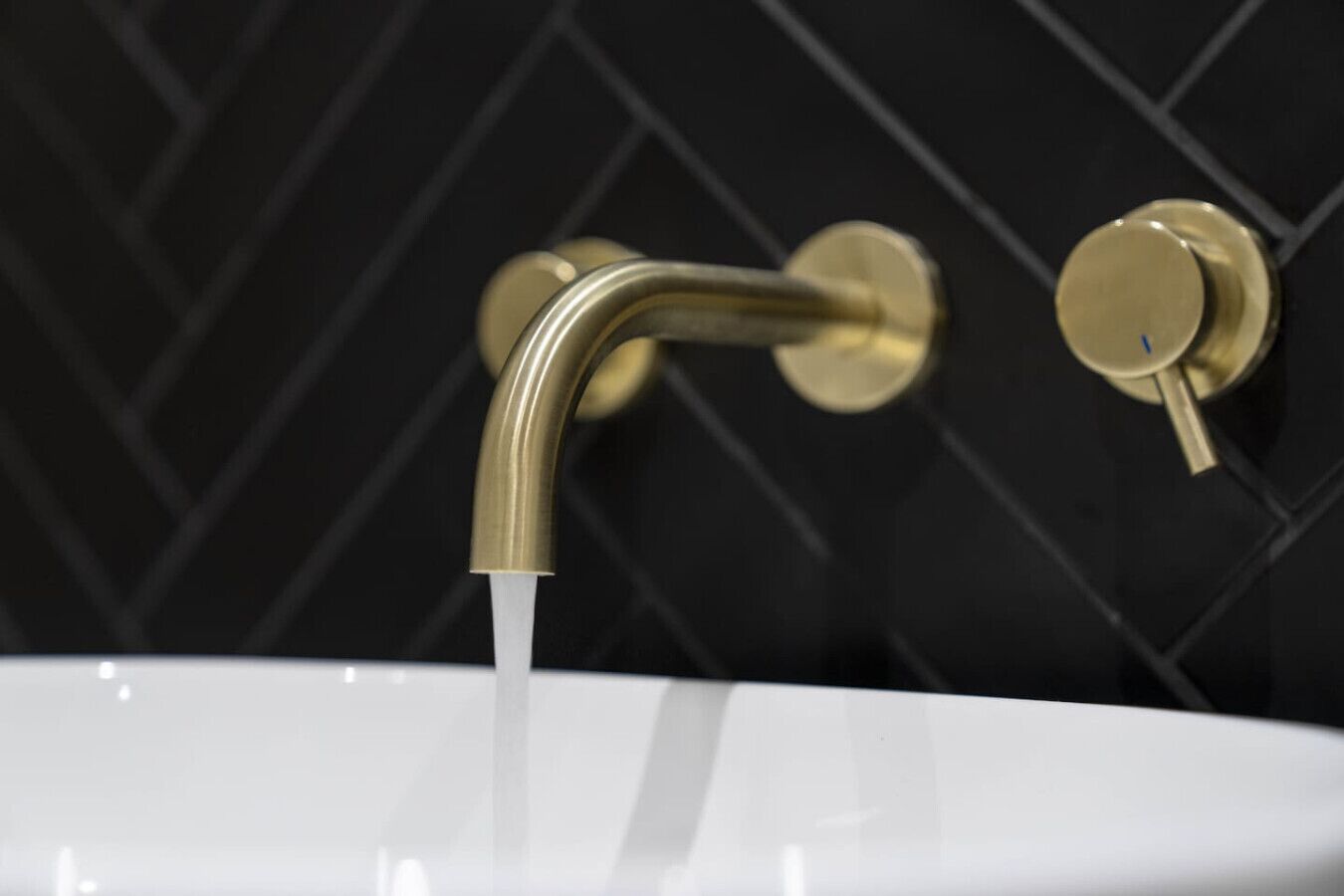 A bathroom sink with a curved faucet and a single lever handle.