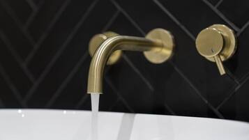 A bathroom sink with a curved faucet and a single lever handle.
