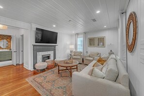 A spacious living room with a fireplace, comfortable seating, and a television. - Bungalow Off Floyd St In The Heart Of Covington 3 Bedroom Bungalow (Covington)