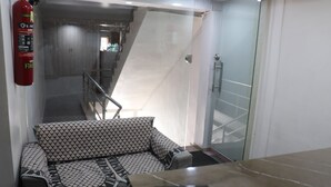 Ein modernes Interieur mit einer Couch, einem Feuerlöscher, einer Treppe und einer Glastür.