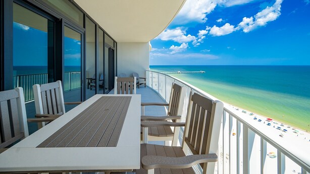 Ein Balkon mit Blick auf den Ozean und den Strand.