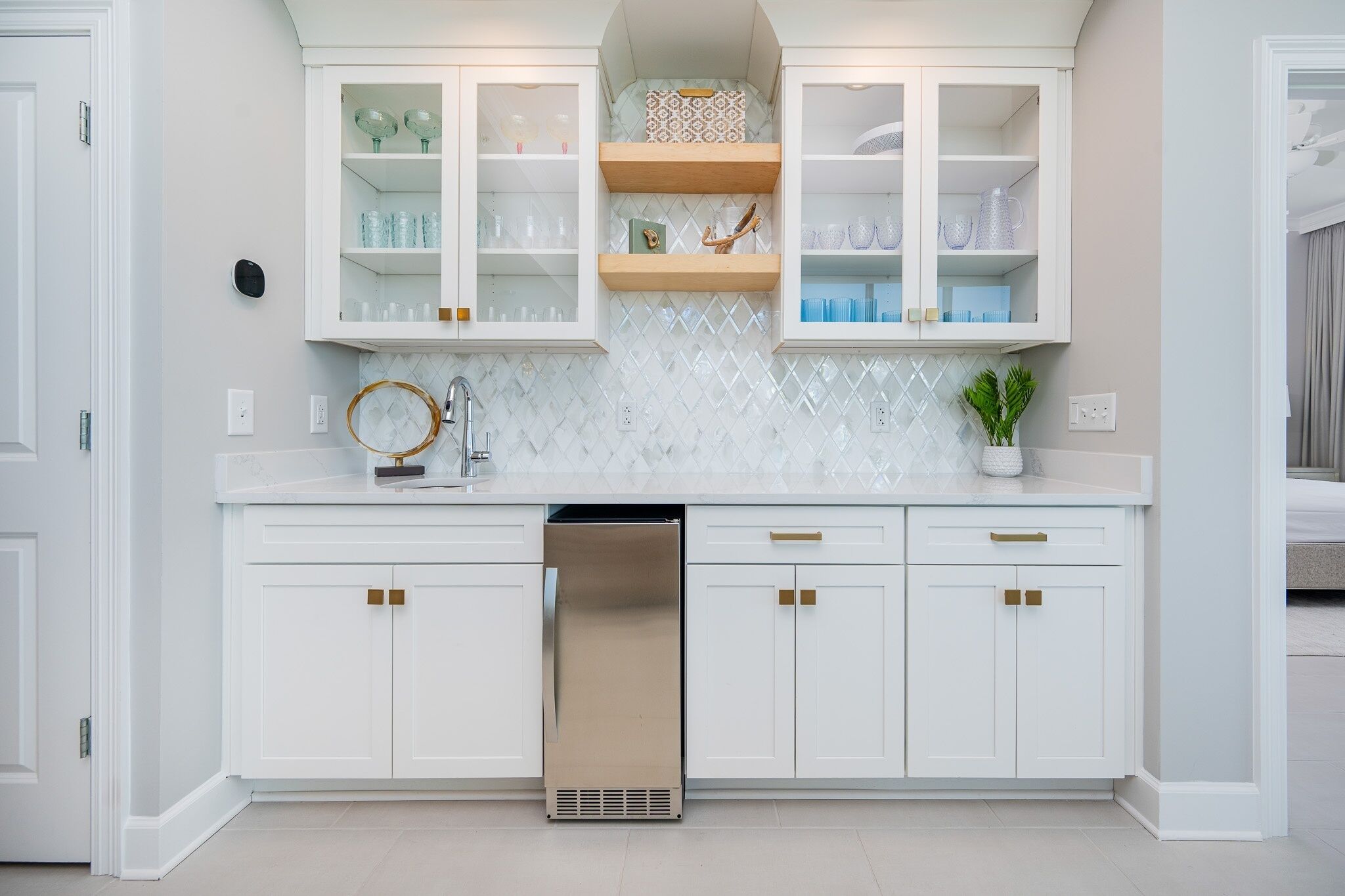 Una cocina moderna con armarios blancos, lavavajillas integrado y salpicadero de azulejos.
