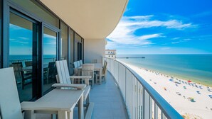 A balcony with a view of the beach and ocean.